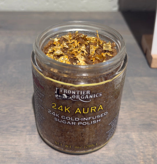Open jar of Frontier Organics 24K Aura Sugar Polish topped with gold leaf